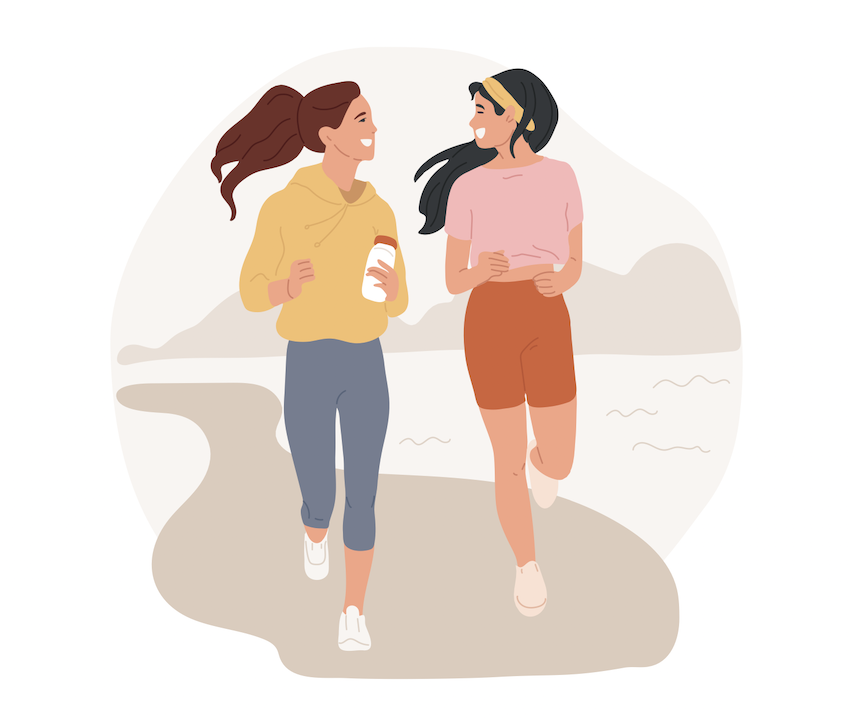 Two young women jogging together outside