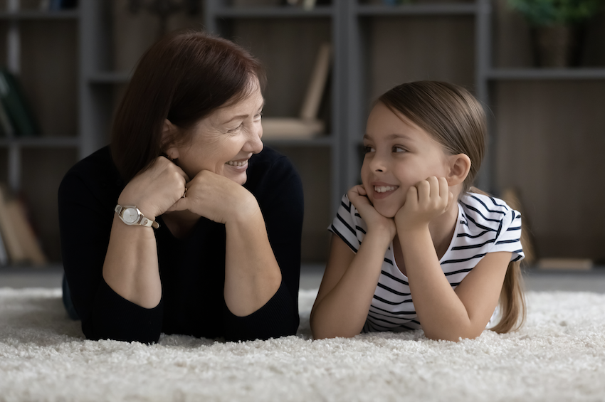 Intergenerational relationships: Elderly woman and young girl smiling at each other