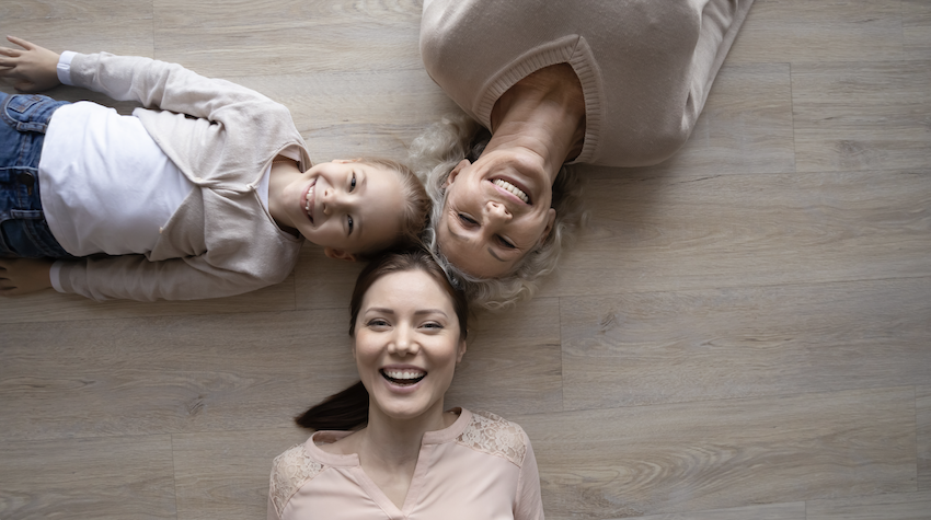 Intergenerational relationships - elderly woman, young woman and young girl lay down together